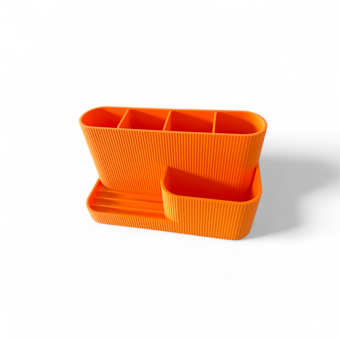 Orange desk organiser with built-in phone stand and pen slots, matte ribbed texture