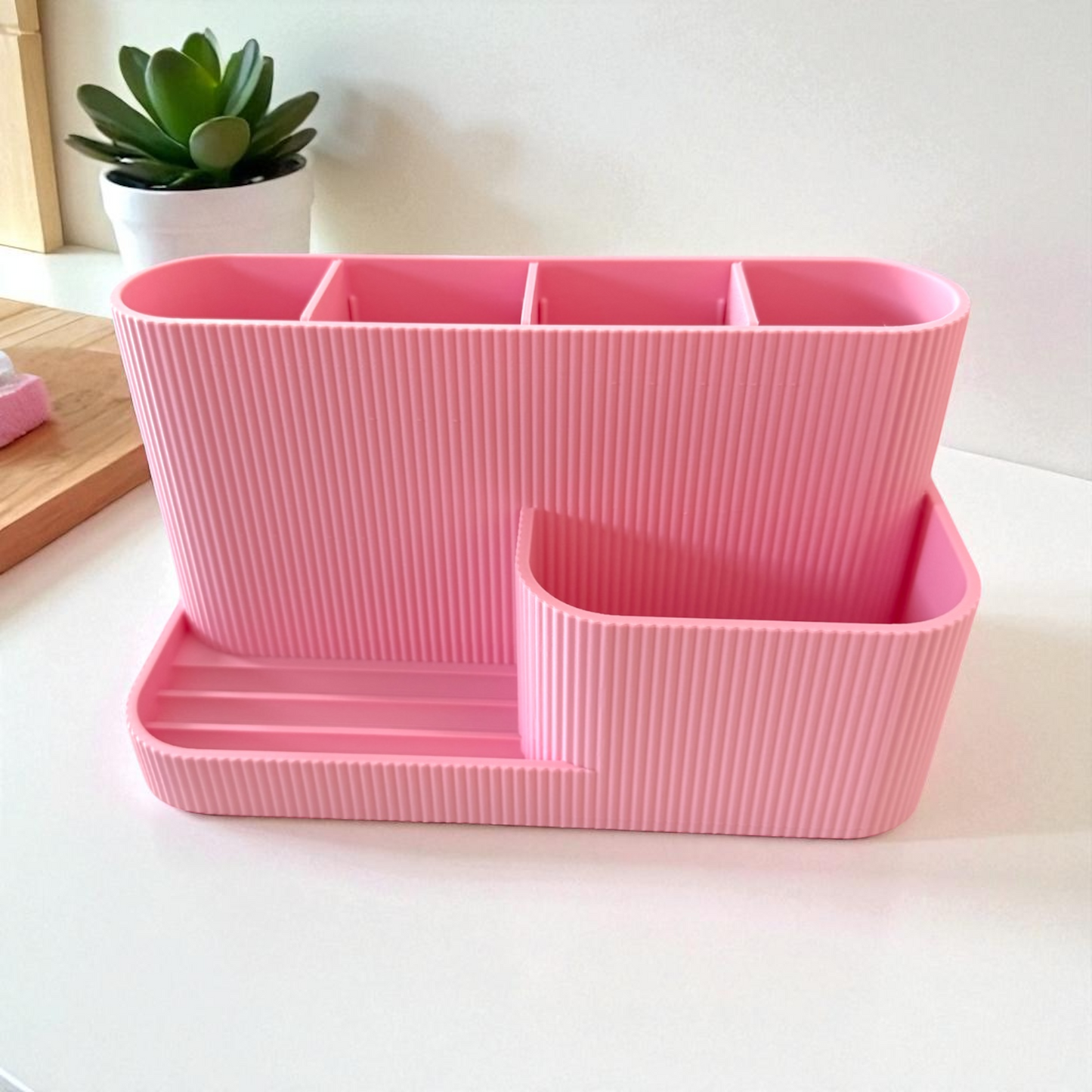 Soft pink desk organiser with built-in phone stand and pen slots