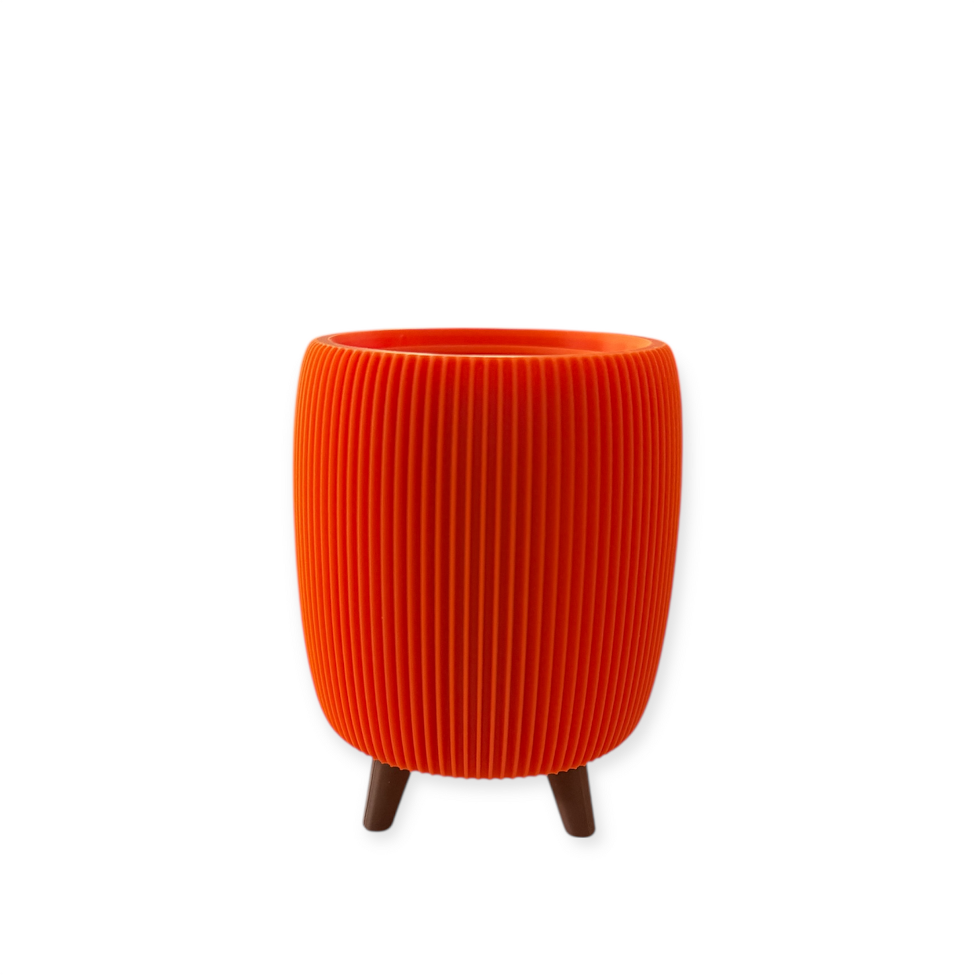 Small vibrant orange retro ribbed planter with raised feet and liner insert for indoor plants
