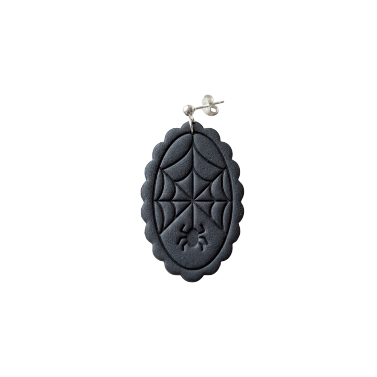 A black oval dangle earring featuring an embossed spiderweb design and a small spider motif near the bottom, suspended from a silver post against a plain white background.
