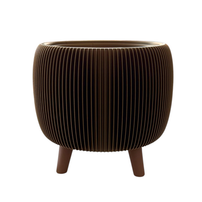 A modern round side table or planter with a dark brown ribbed, pleated design and three short legs, shown against a plain white background.